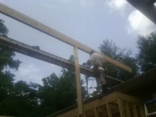 Carpenter setting a ridge beam over a new addition frame — Ice Dam Removal by Roofing Brothers in Albrightsville