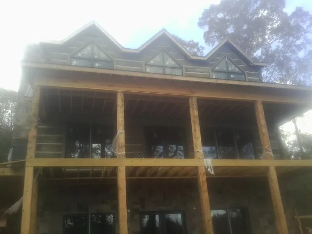 Dormers and porch framing on a large log home under construction — Roof Coating work by our crew in Albrightsville