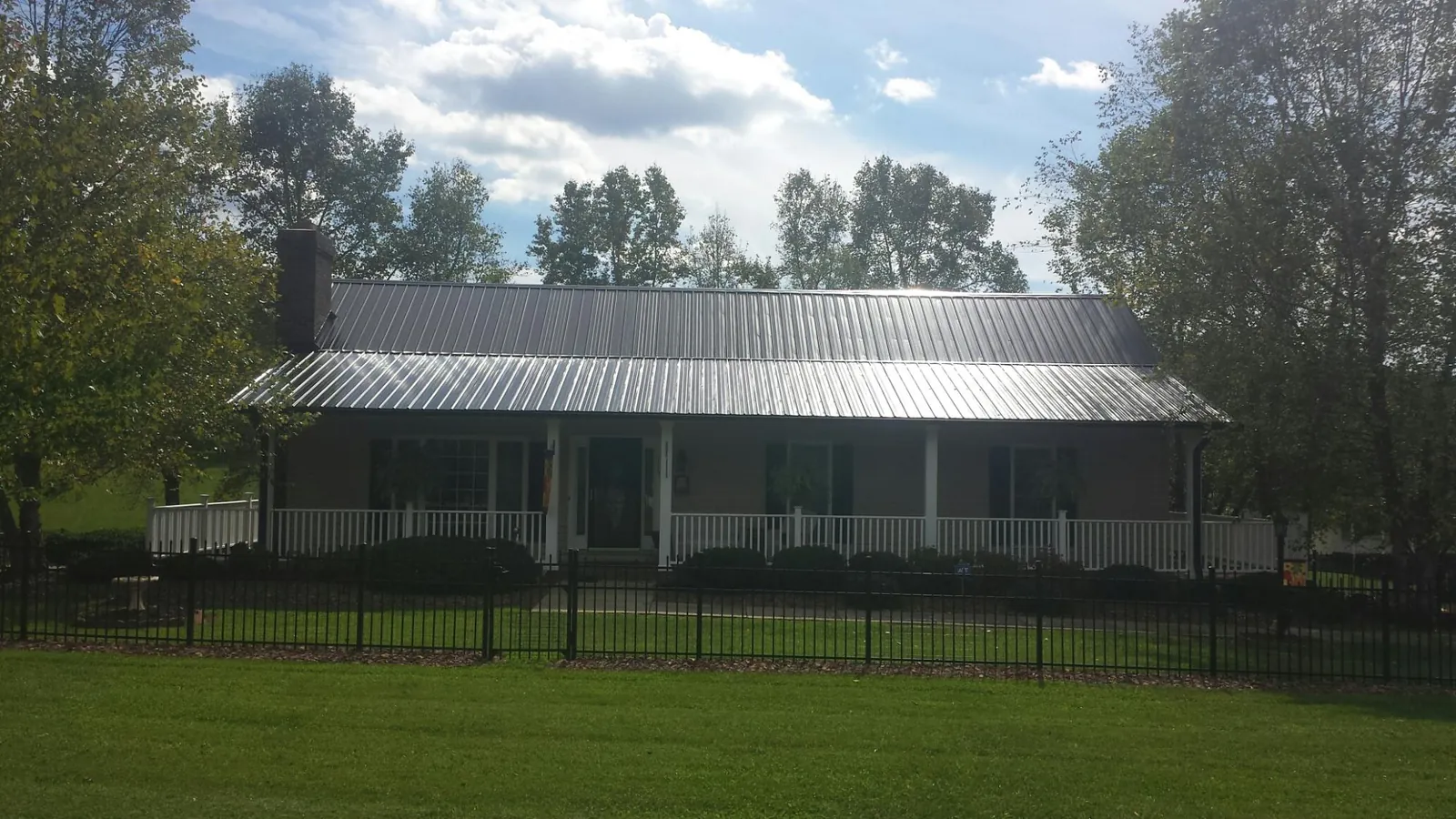 Gray metal roof on a brick ranch with a full width front porch — Gutter Guard Installation work by our crew in Albrightsville
