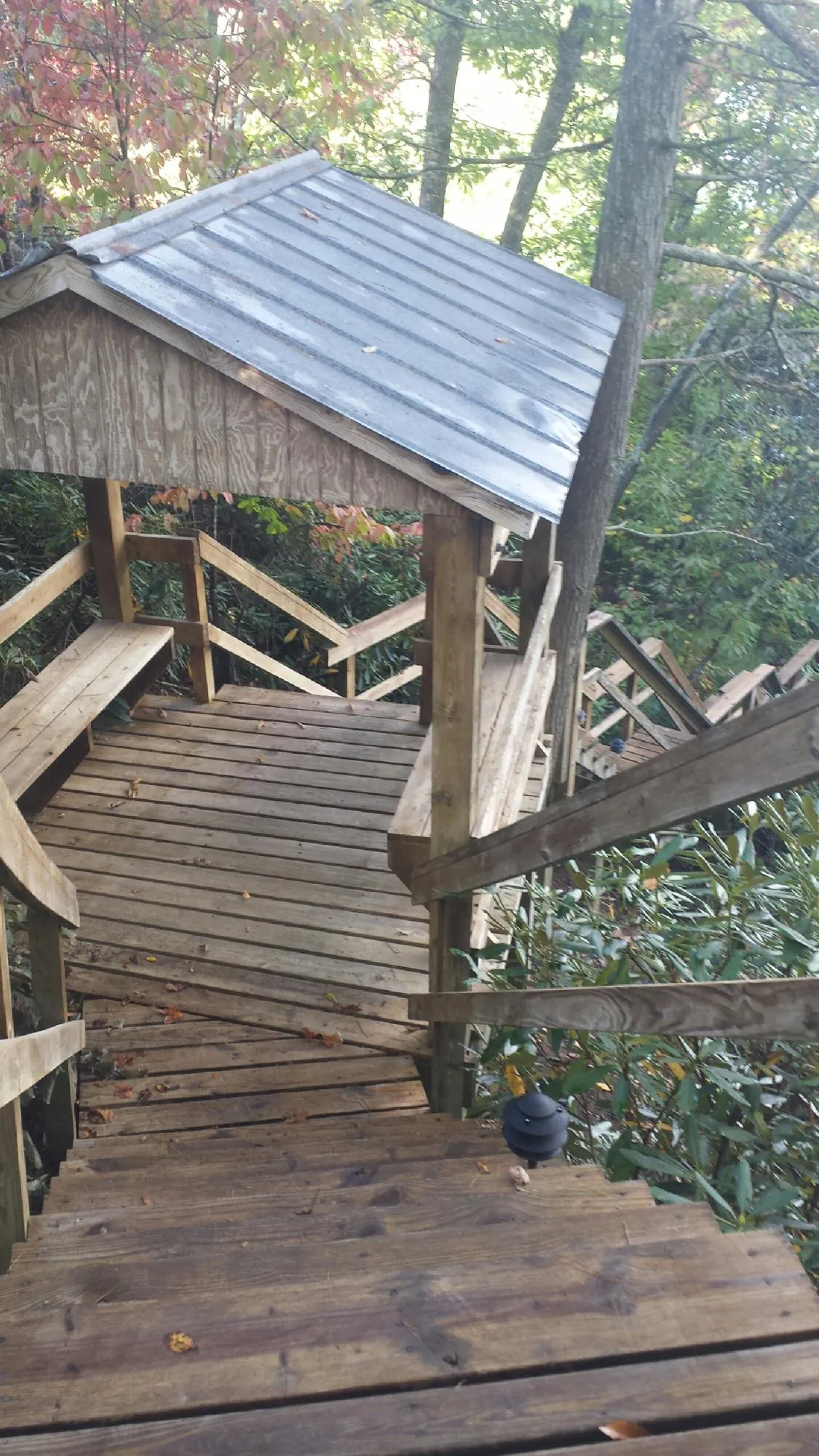 Metal roofed shelter over wooden steps on a wooded walkway — Skylight Repair & Installation work by our crew in Albrightsville